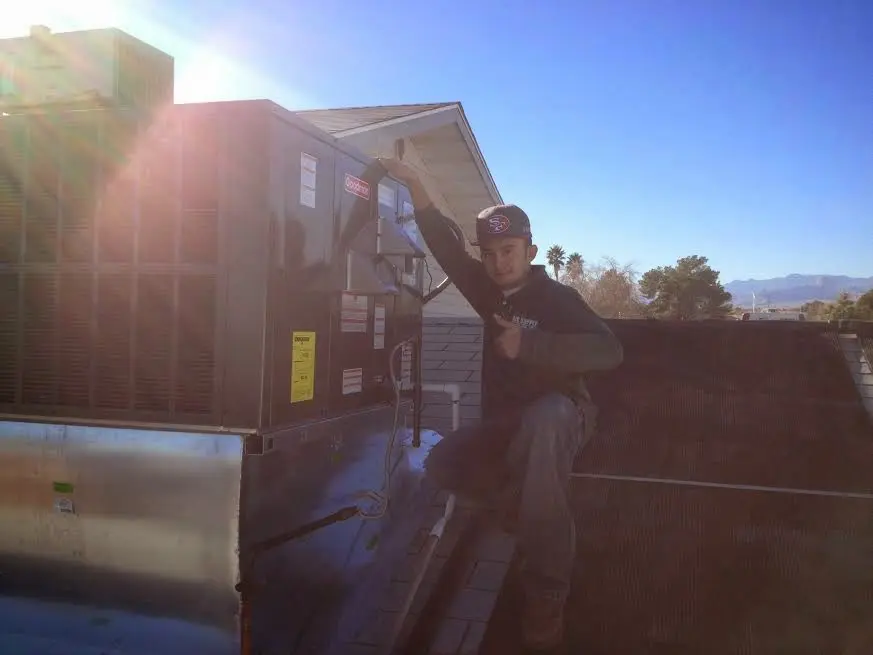 HVAC technician performing Air Duct Cleaning on a rooftop unit in Montecito