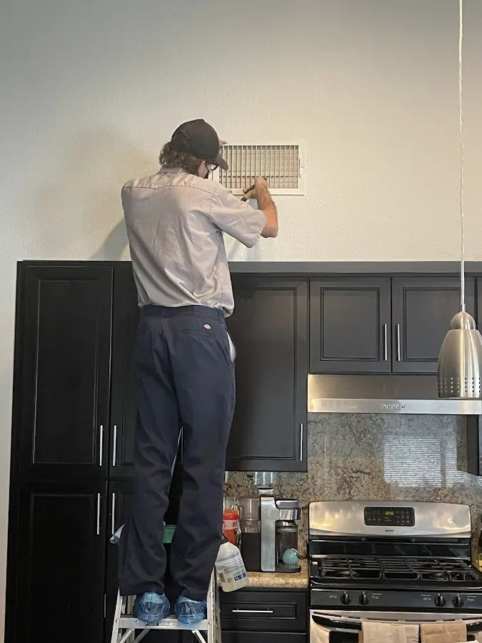 Technician inspecting an air vent during HVAC service in Montecito